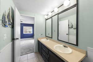 Bathroom with vanity, tile patterned floors, and a textured ceiling