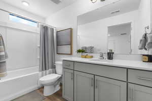 Full bathroom featuring wood-type flooring, toilet, vanity, and shower / bathtub combination with curtain