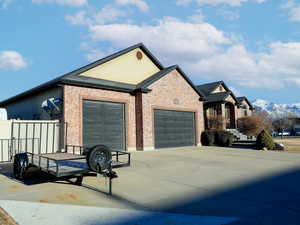 View of side of property with a mountain view and a garage