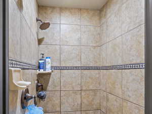 Room details featuring a tile shower