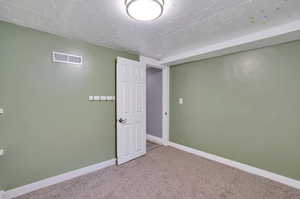 Interior space featuring a textured ceiling and carpet