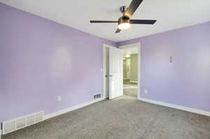 Unfurnished room featuring ceiling fan and carpet