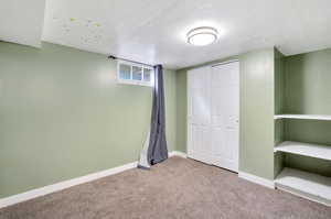 Unfurnished bedroom with carpet floors, a textured ceiling, and a closet