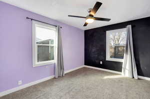 Carpeted empty room with ceiling fan