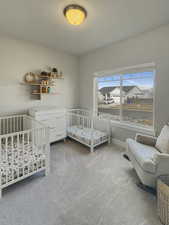 Bedroom featuring carpet and a nursery area