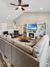 Living room with hardwood / wood-style flooring, lofted ceiling, and ceiling fan