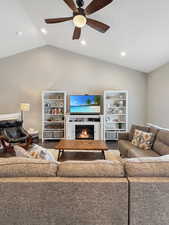 Living room with vaulted ceiling, hardwood / wood-style floors, and ceiling fan