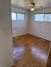 Spare room featuring ceiling fan, hardwood / wood-style floors, and a wealth of natural light