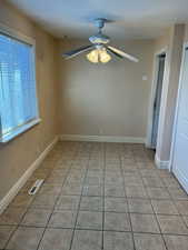 Empty room featuring ceiling fan and light tile patterned flooring