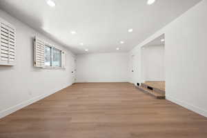 Spare room featuring light wood-type flooring and a textured ceiling