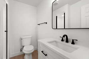 Bathroom featuring wood-type flooring, toilet, and vanity