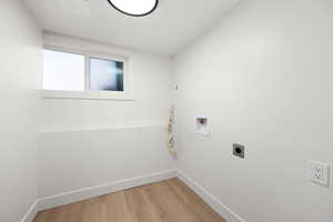 Washroom featuring hardwood / wood-style flooring, washer hookup, and hookup for an electric dryer