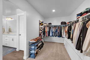 Walk in closet featuring light carpet