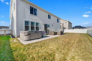 Back of house with a patio area, outdoor lounge area, a yard, and a hot tub