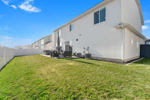 Rear view of property featuring central AC unit, a patio area, a lawn, and outdoor lounge area