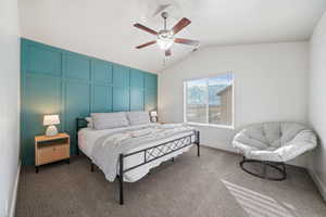 Carpeted bedroom with lofted ceiling and ceiling fan