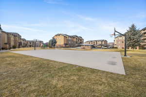 View of basketball court featuring a yard and a playground