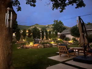 Yard at dusk with a mountain view and a patio