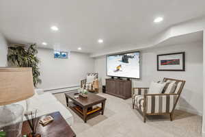 Carpeted living room featuring a baseboard radiator