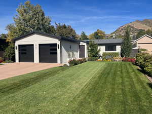 Ranch-style home with a garage, a mountain view, and a front yard