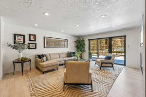 Living room featuring light hardwood / wood-style floors and a textured ceiling