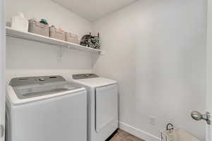 Laundry area with light wood-type flooring and washing machine and dryer