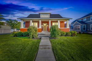 Bungalow-style house with covered porch and a lawn