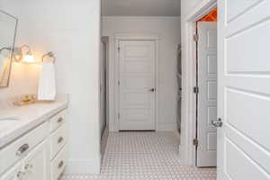 Bathroom with stacked washer and dryer, walk in shower, and vanity