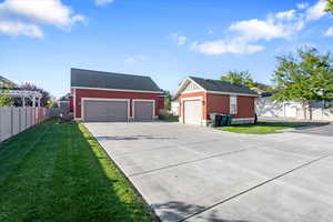 View of house with a back lawn and a garage