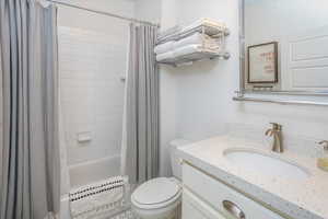 Full bathroom featuring toilet, vanity, and shower / bath combo with shower curtain