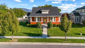 View of front of property with a mountain view, a porch, and a front yard