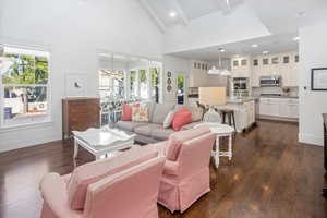 Living room featuring a healthy amount of sunlight, dark wood  flooring, and beamed ceiling