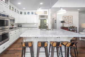 Kitchen featuring appliances with stainless steel finishes, a kitchen bar, a center island with sink