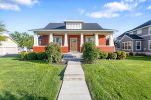 Bungalow-style home with covered porch and a front yard