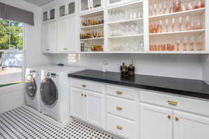 Laundry area featuring washing machine and clothes dryer and cabinets