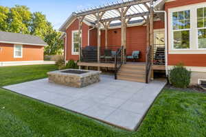 View of patio with a pergola and a fire pit