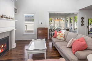 Living room with a tiled fireplace and dark hardwood