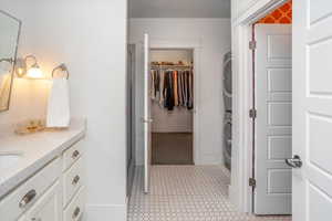 Bathroom featuring stacked washer / drying machine and vanity