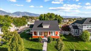 View of front facade featuring a mountain view, a front lawn, and a porch