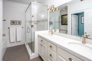 Bathroom featuring tile patterned flooring, vanity, ornamental molding, and plus walk in shower