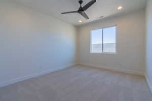 Unfurnished room with light colored carpet and ceiling fan