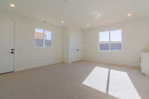 Unfurnished room with light colored carpet and a healthy amount of sunlight