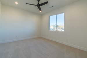 Spare room featuring ceiling fan and light carpet