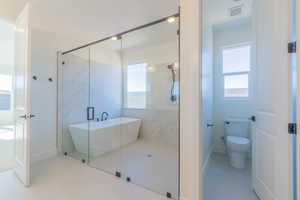 Bathroom featuring independent shower and bath, toilet, and tile patterned flooring