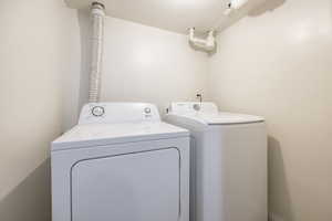 Washroom featuring a textured ceiling and washer and dryer