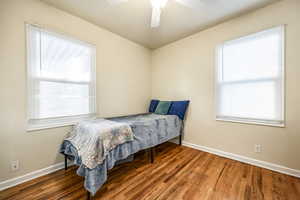 Bedroom featuring ceiling fan and dark hardwood / wood-style flooring