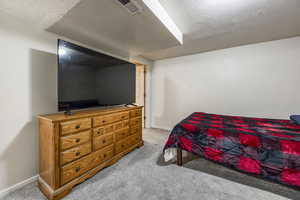 Bedroom with light carpet and a textured ceiling