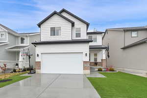 View of front of property featuring a garage and a front yard