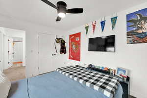 Bedroom featuring ceiling fan, carpet, and a closet