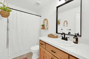 Bathroom with toilet, vanity, and tile patterned flooring